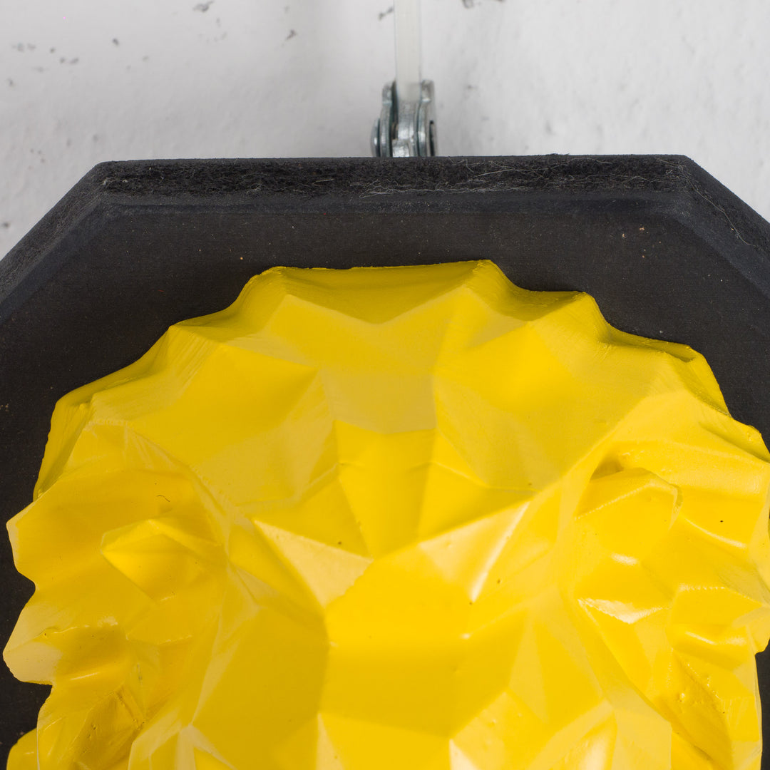 Artwork of a lion head in yellow in resin