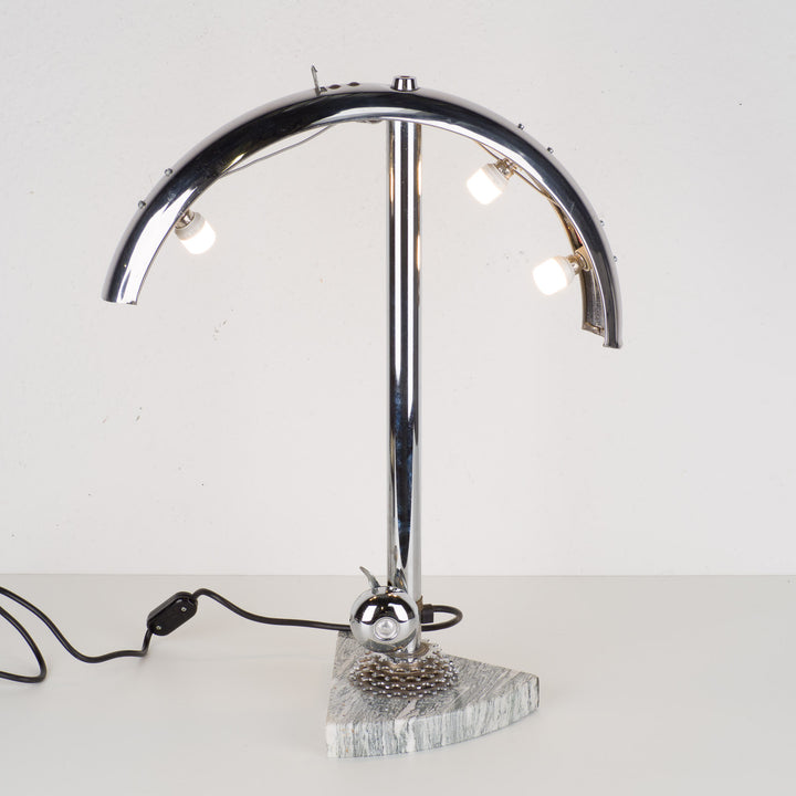 Fun metal table lamp with bicycle bell on a marble base.