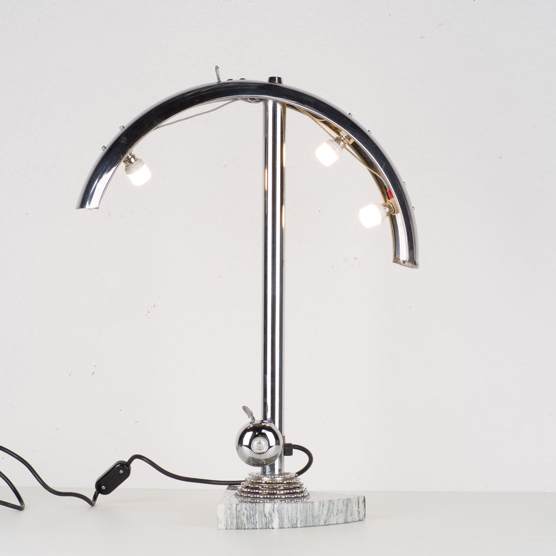 Fun metal table lamp with bicycle bell on a marble base.