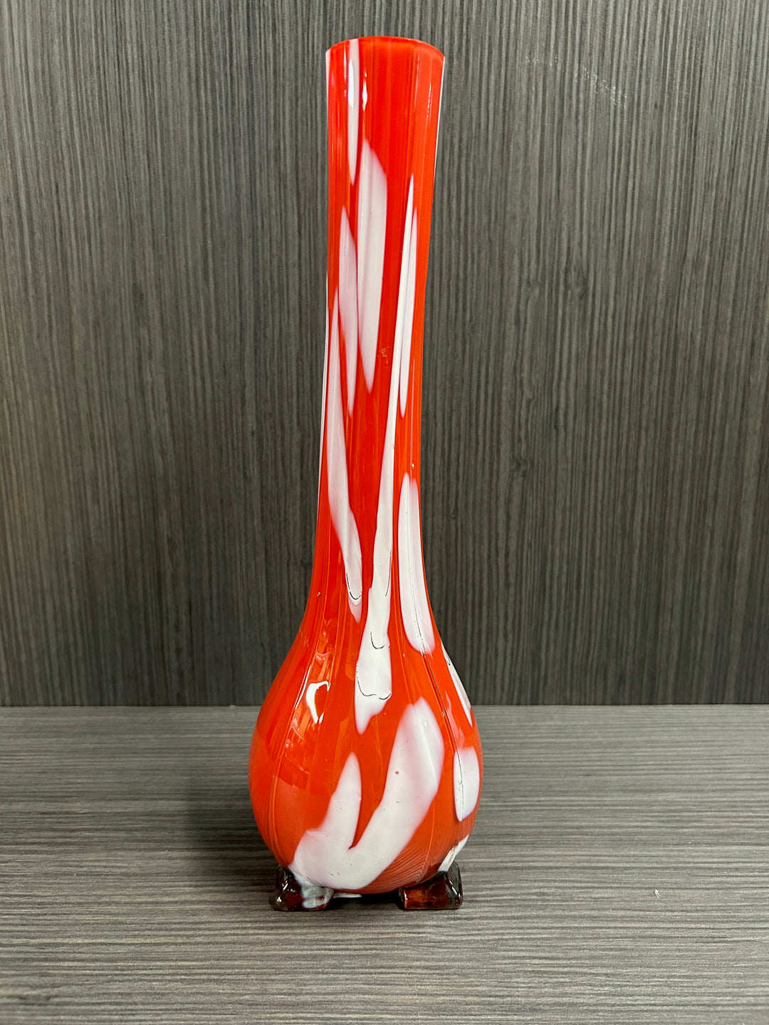 A red glass vase with white accents