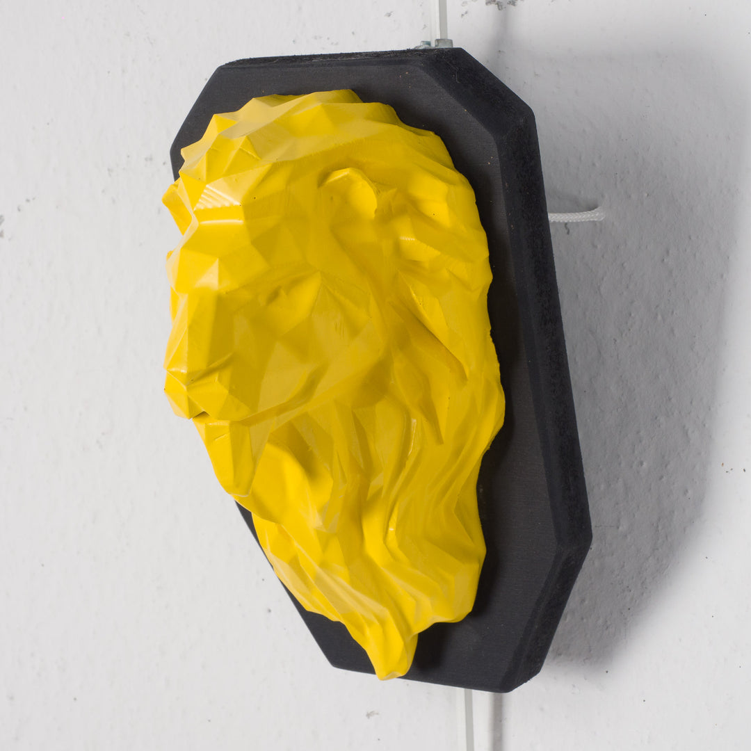 Artwork of a lion head in yellow in resin