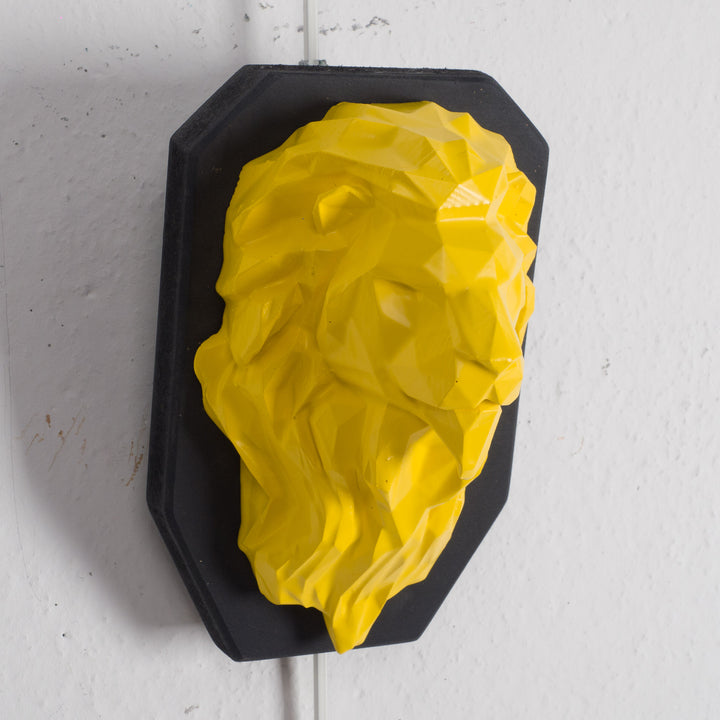 Artwork of a lion head in yellow in resin