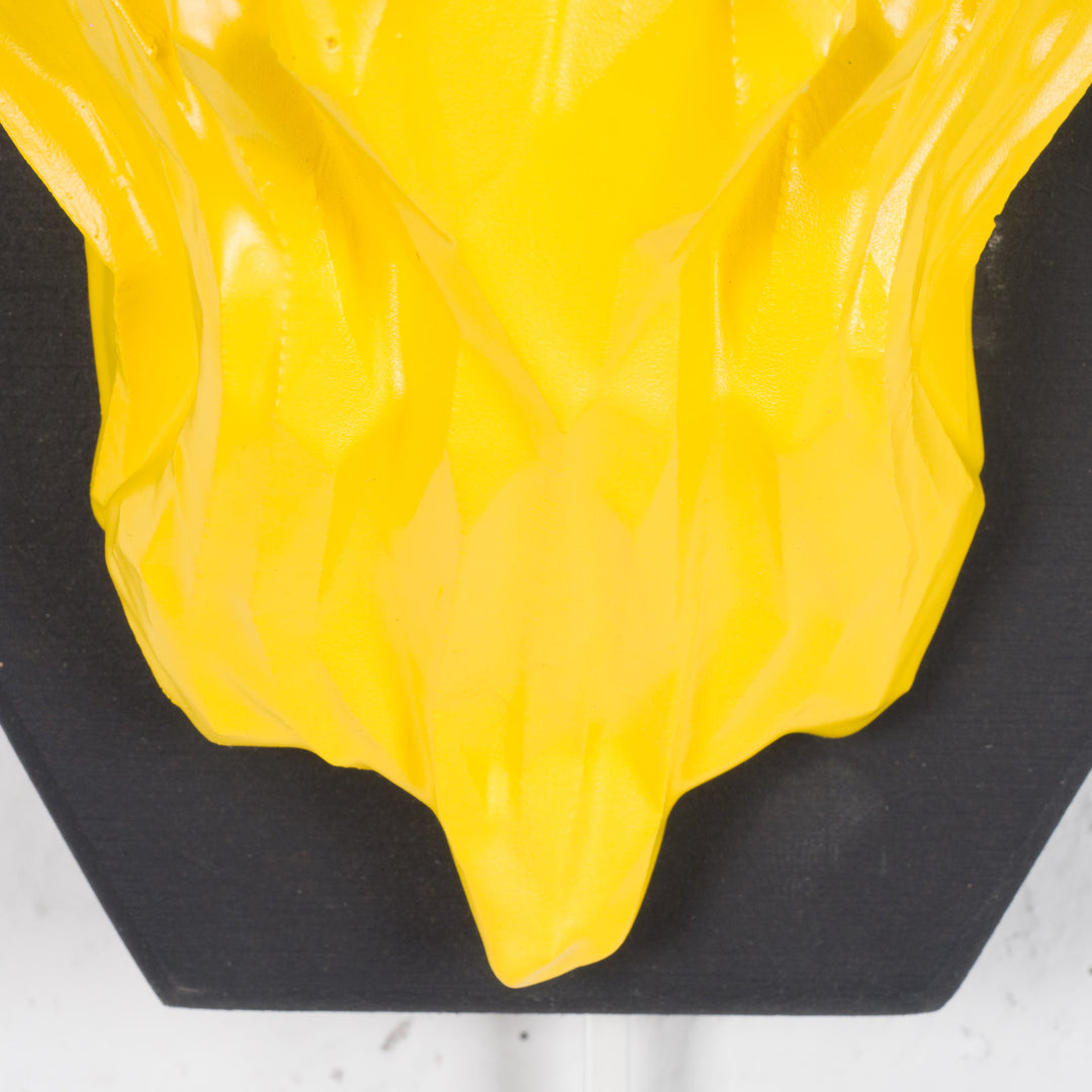 Artwork of a lion head in yellow in resin