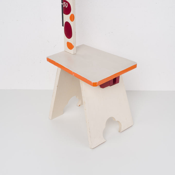 Fun wooden stool with a measuring stick in orange