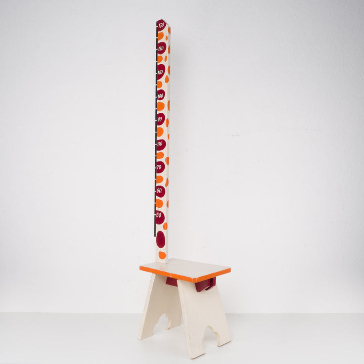 Fun wooden stool with a measuring stick in orange